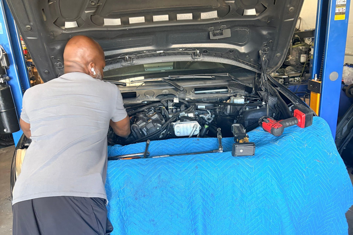 Technician Performing Engine Repair Service In Shop Bay | Extreme Boost Care