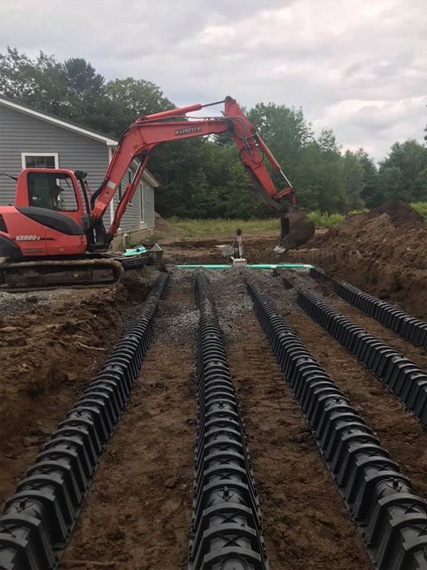 HVAC technician in red shirt installing air conditioning units on a white house exterior.