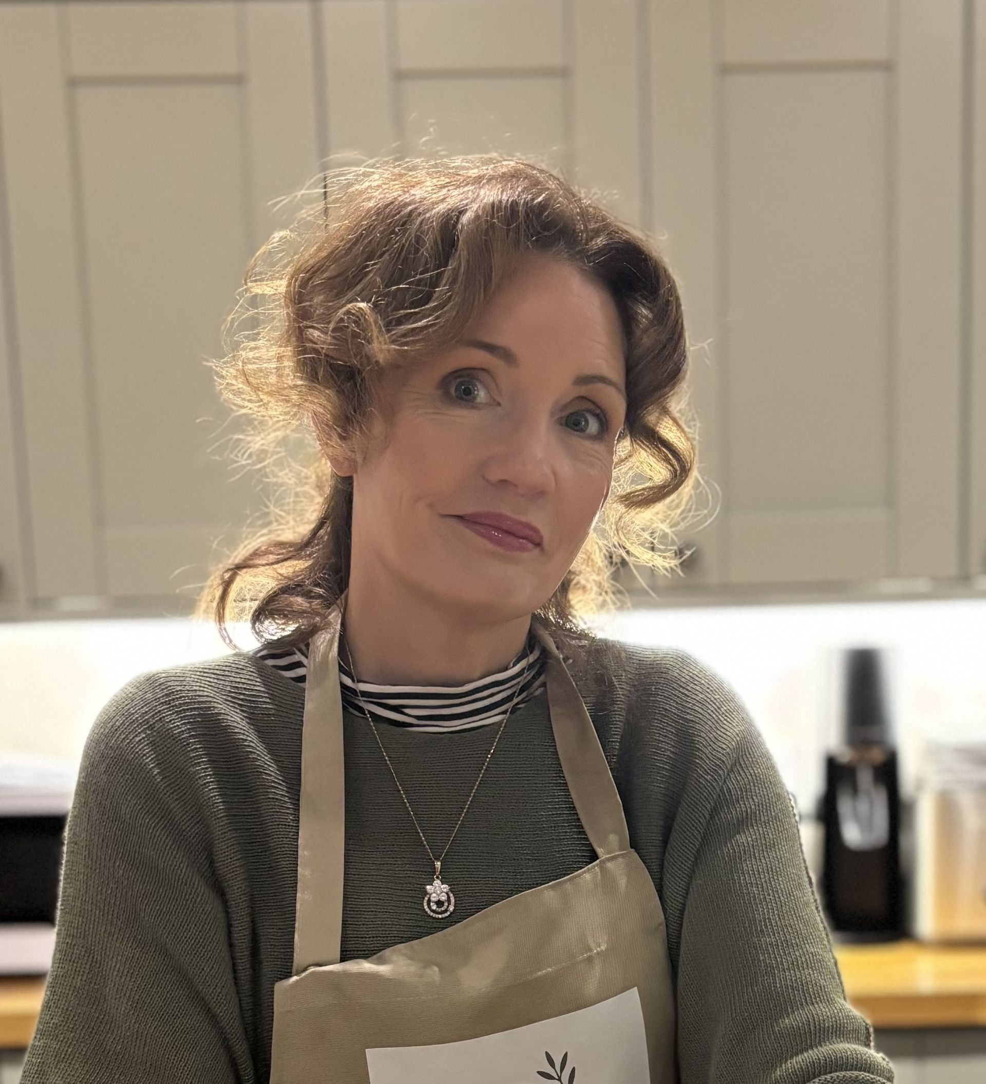Breakfast tray with pastries, strawberries, and sauces on a pink table, set near pillows and a blanket.