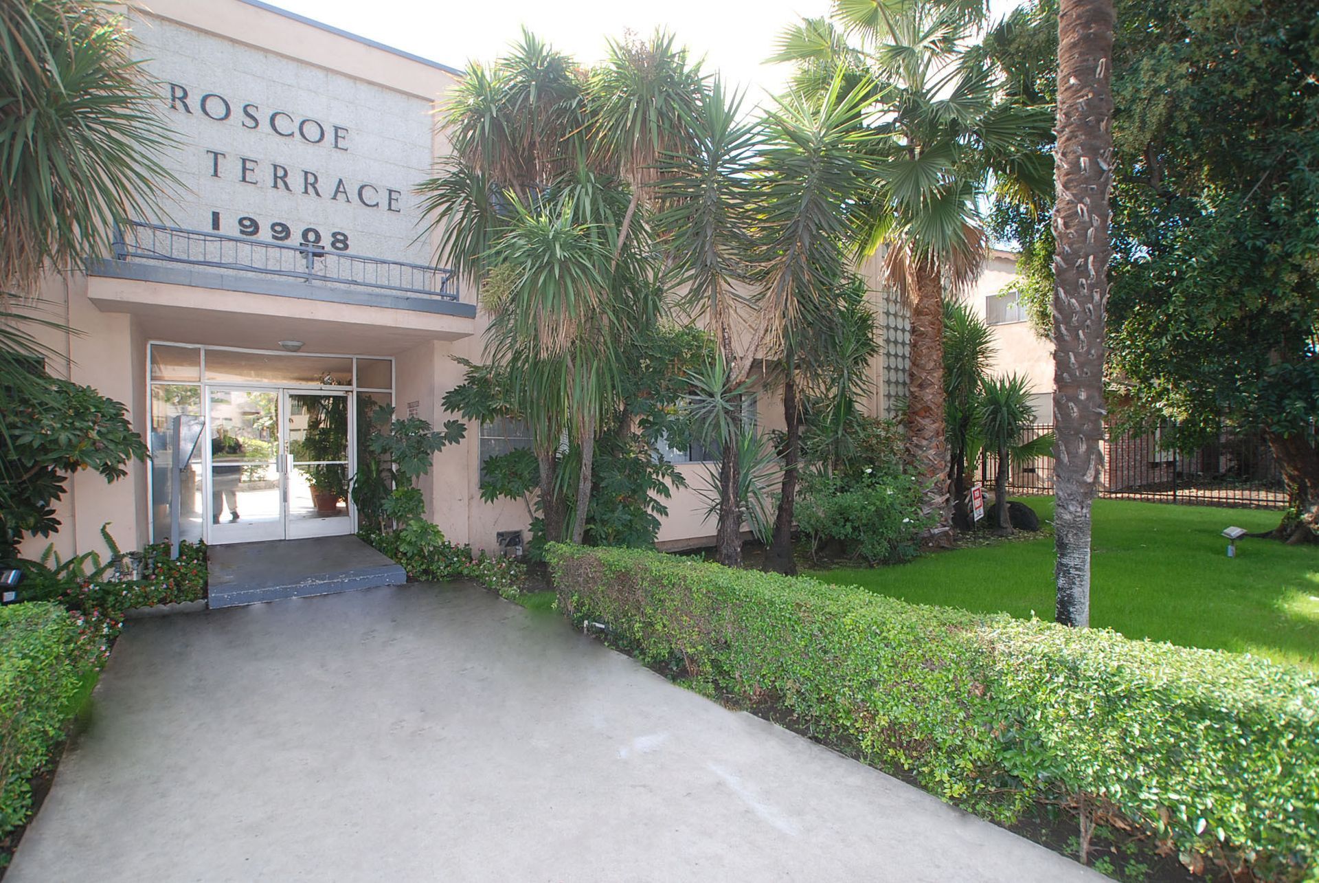 Roscoe Terrace apartment building entrance, 19302, with pathway and greenery.