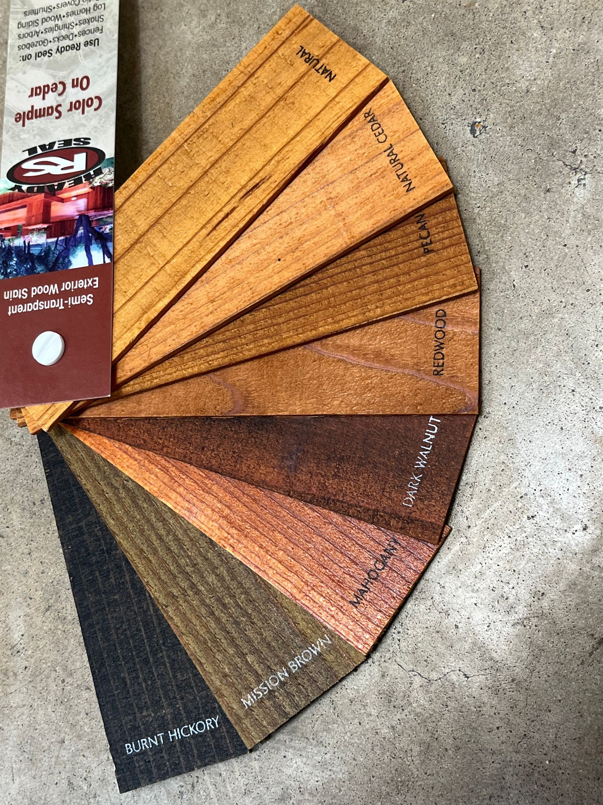 Minimalist black chain link fence enclosing a yard with a backdrop of lush green trees.