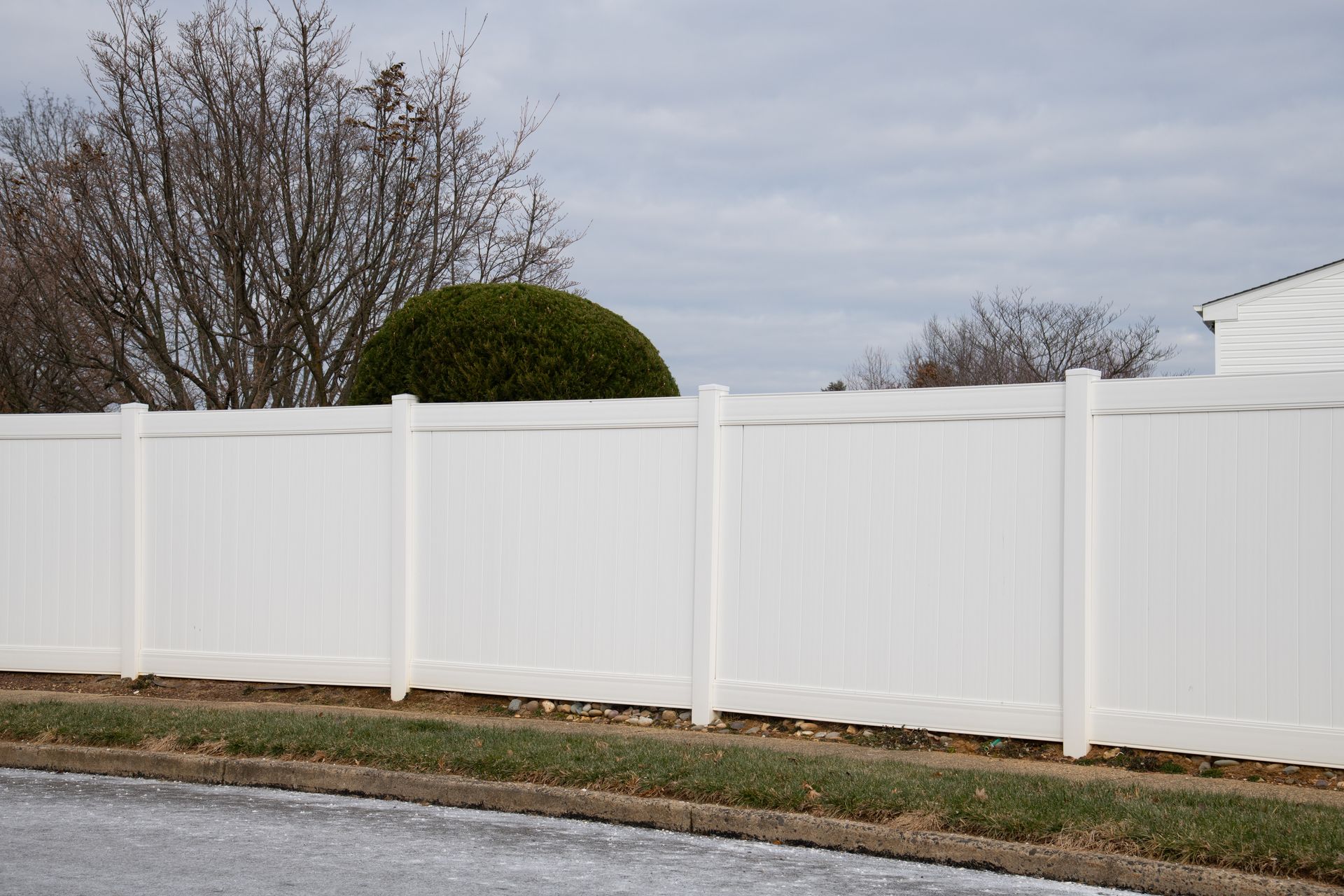 White vinyl fence surrounding a picturesque home in a peaceful residential neighborhood, adding a touch of elegance to the landscape.