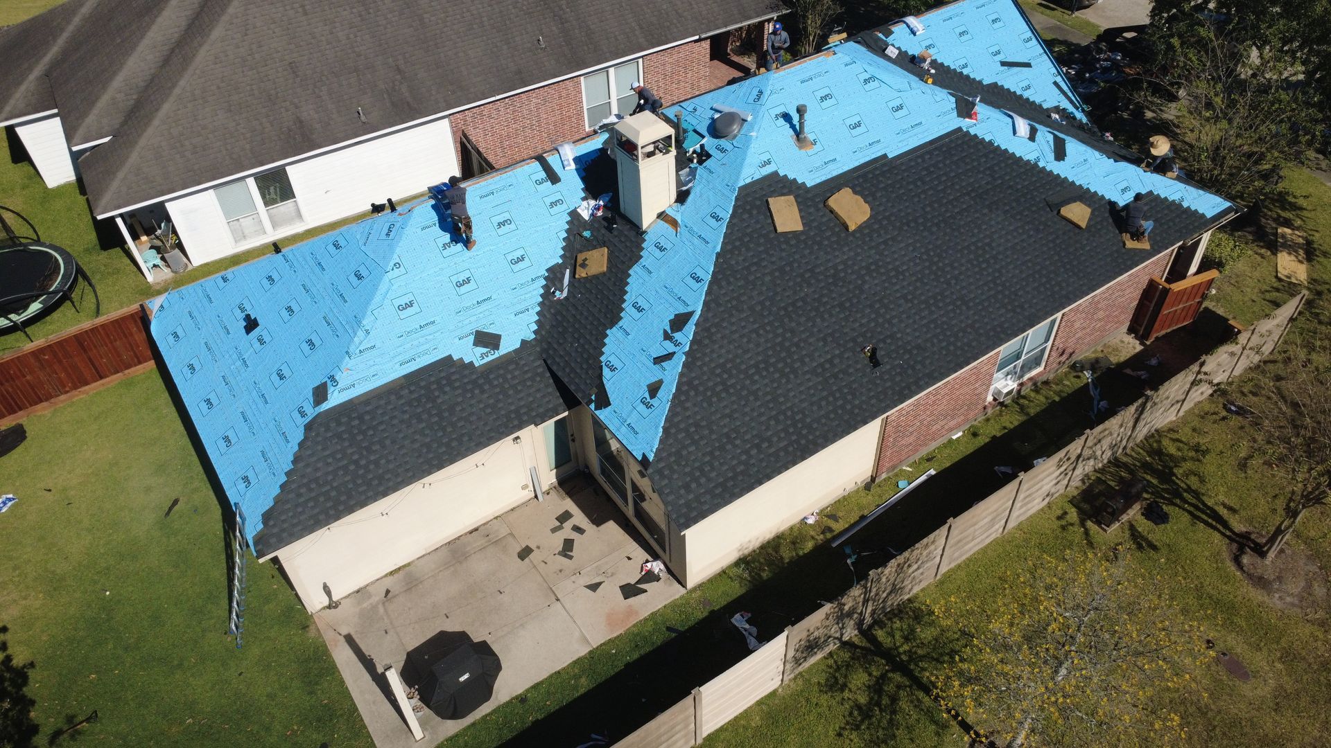 Scenic view of a well-maintained white vinyl fence surrounding a private backyard.