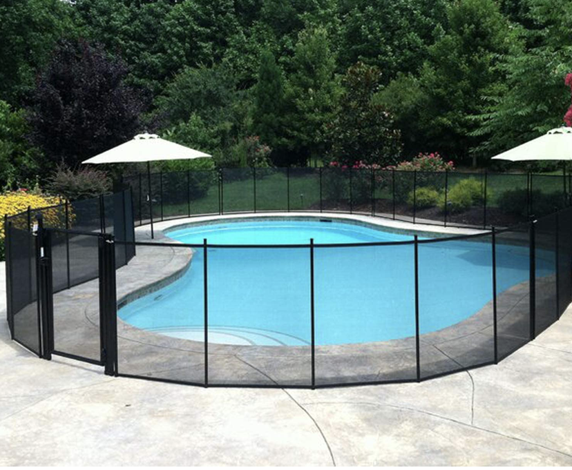 Stack of vertical slat replacement fence panels in a residential backyard, prepared for installation.