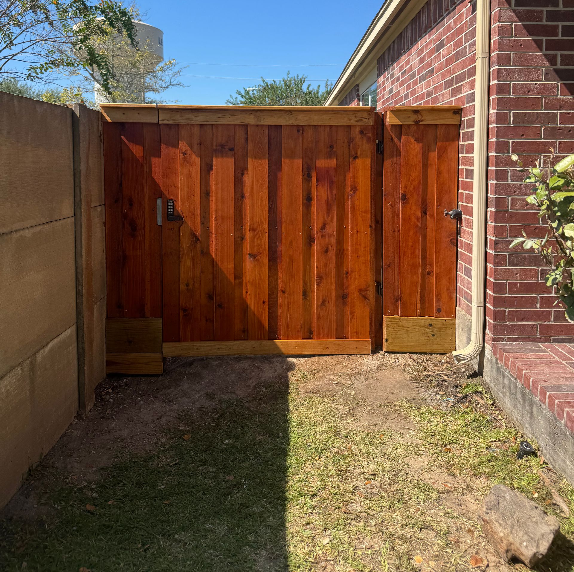 Aged wooden fence near new lumber boards.