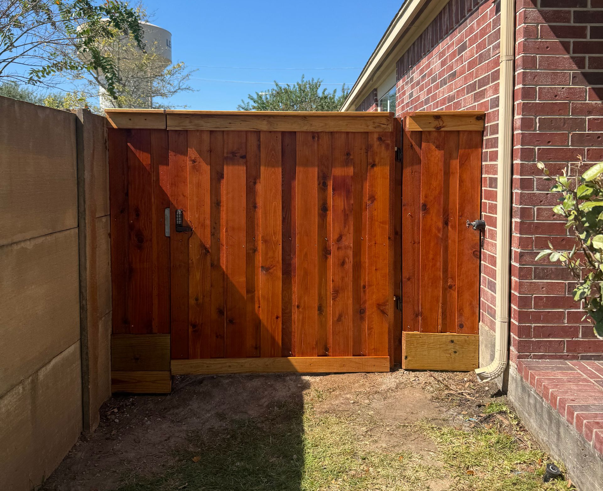 Aged wooden fence near new lumber boards.