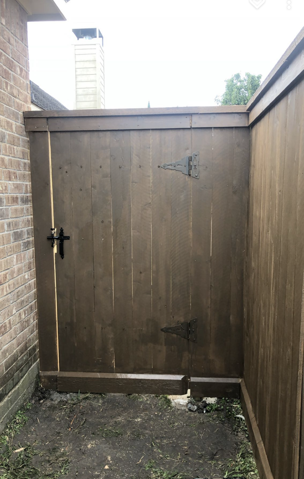 Aged wooden fence near new lumber boards.