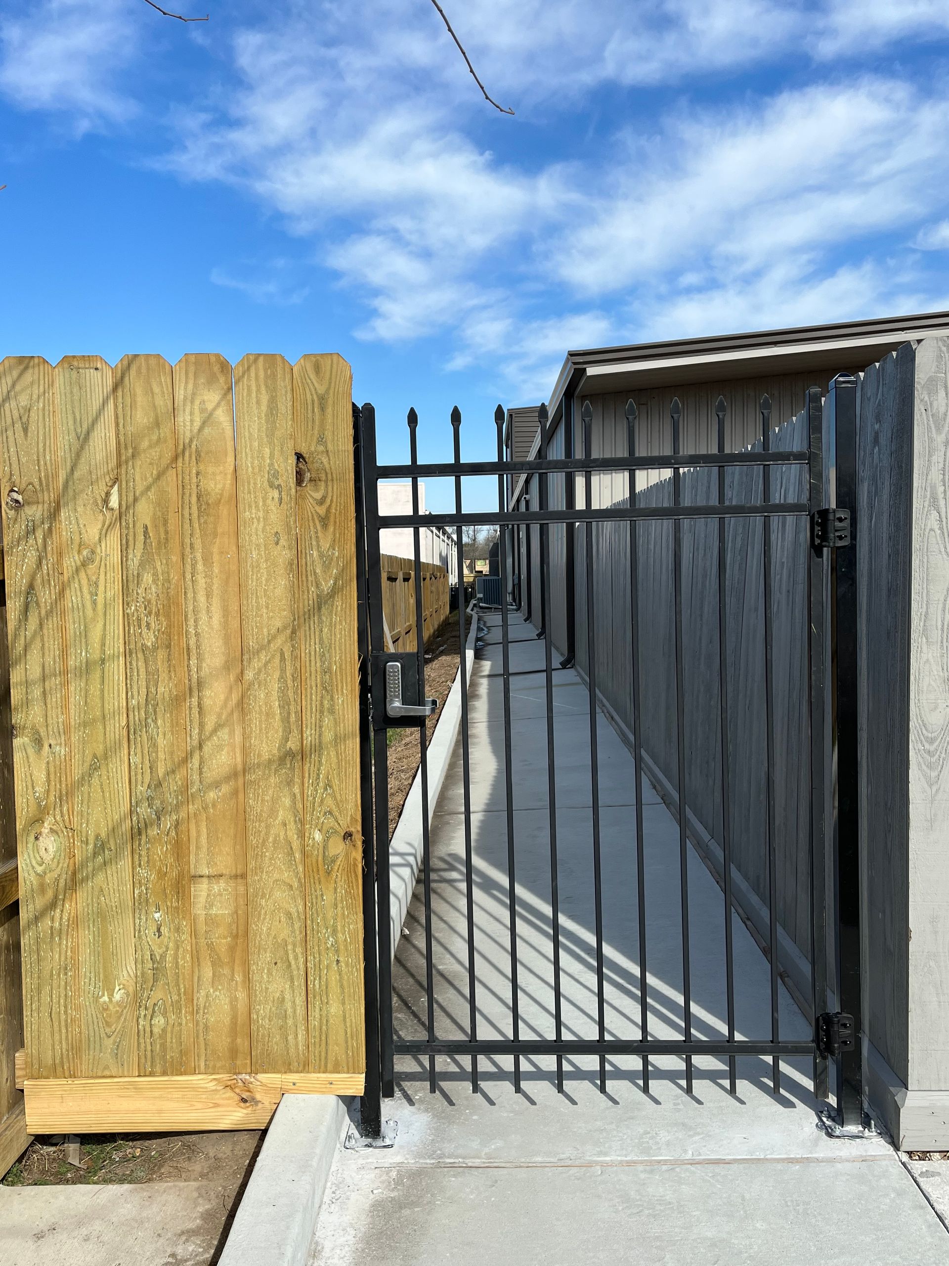 Aged wooden fence near new lumber boards.