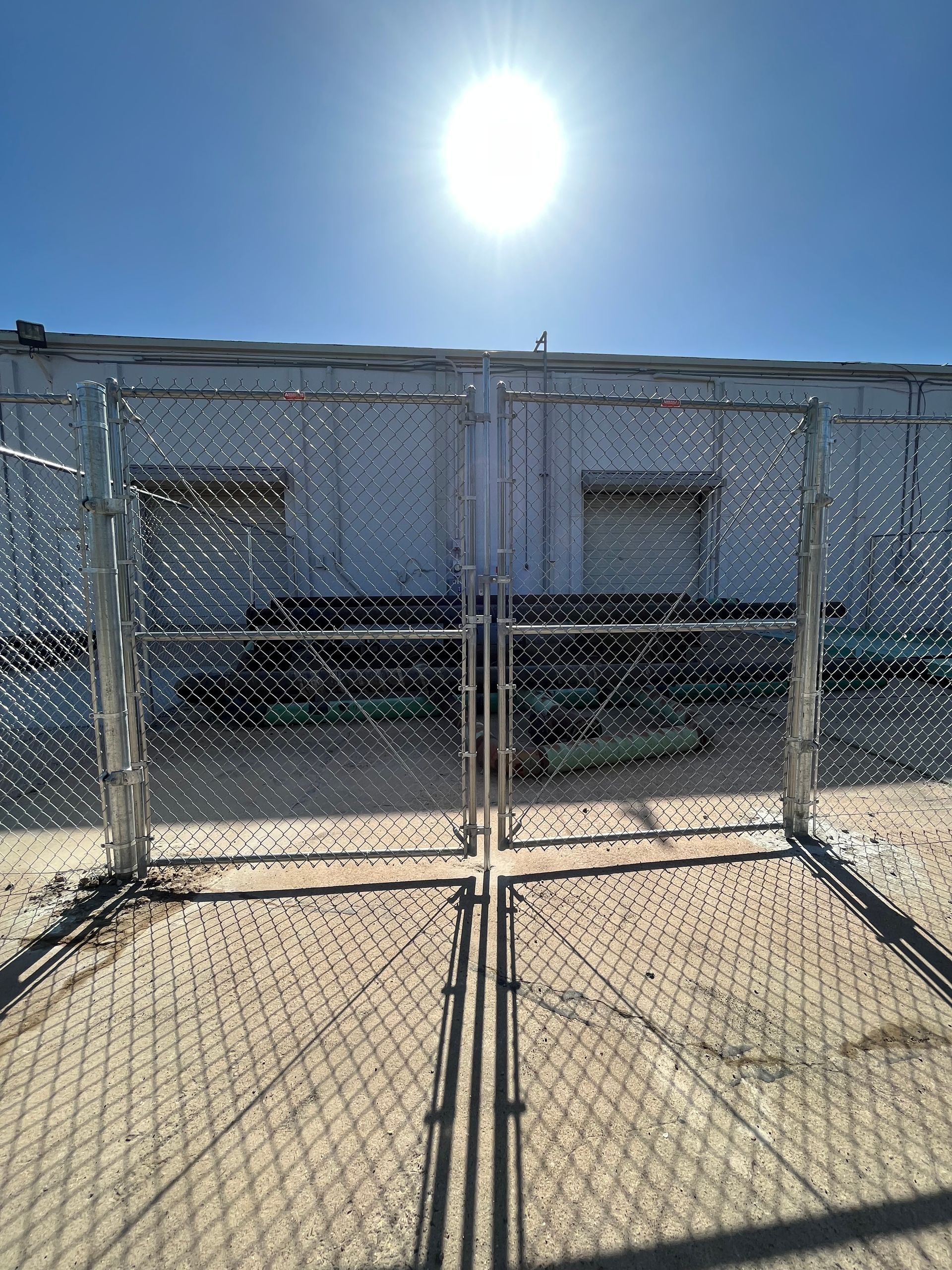 Stack of vertical slat replacement fence panels in a residential backyard, prepared for installation.