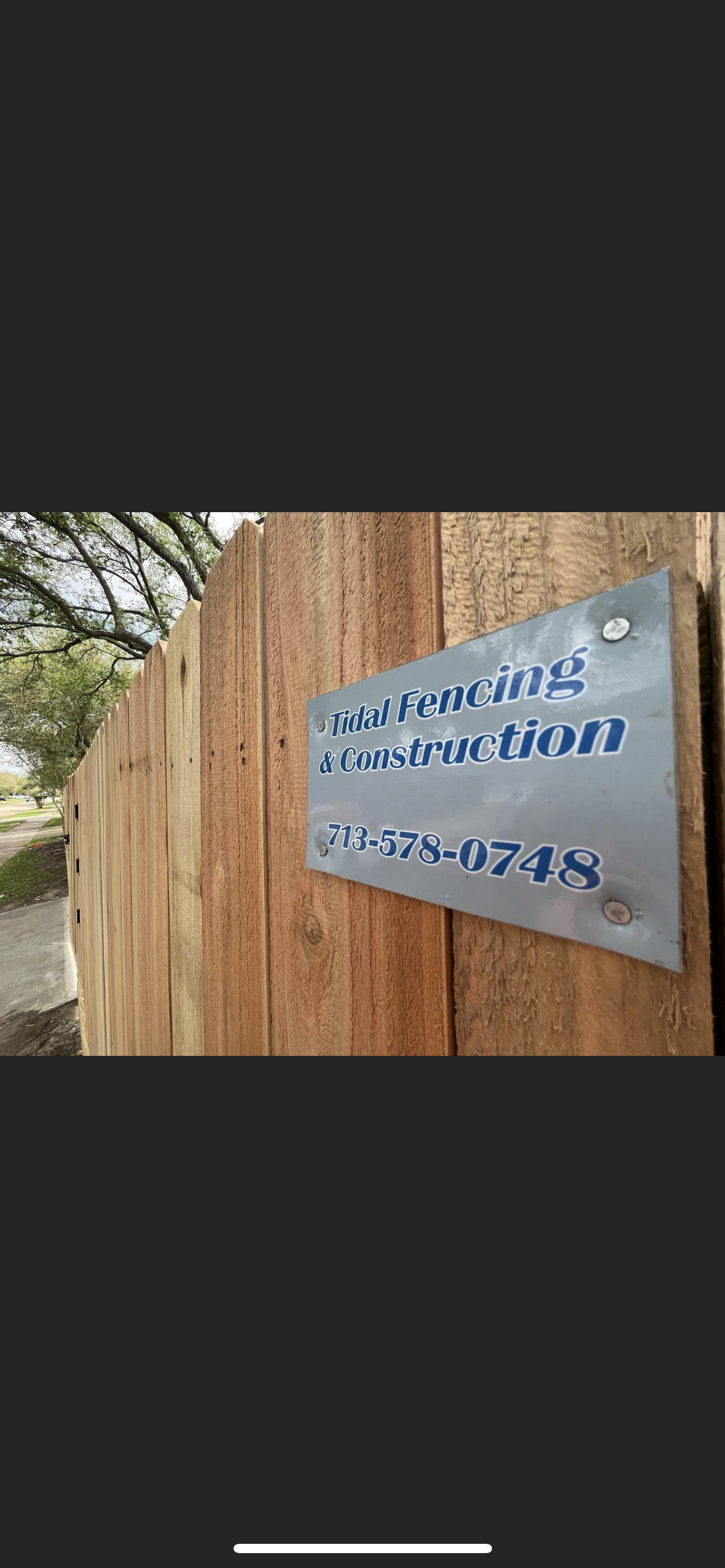 Sign on a wooden fence, text reads