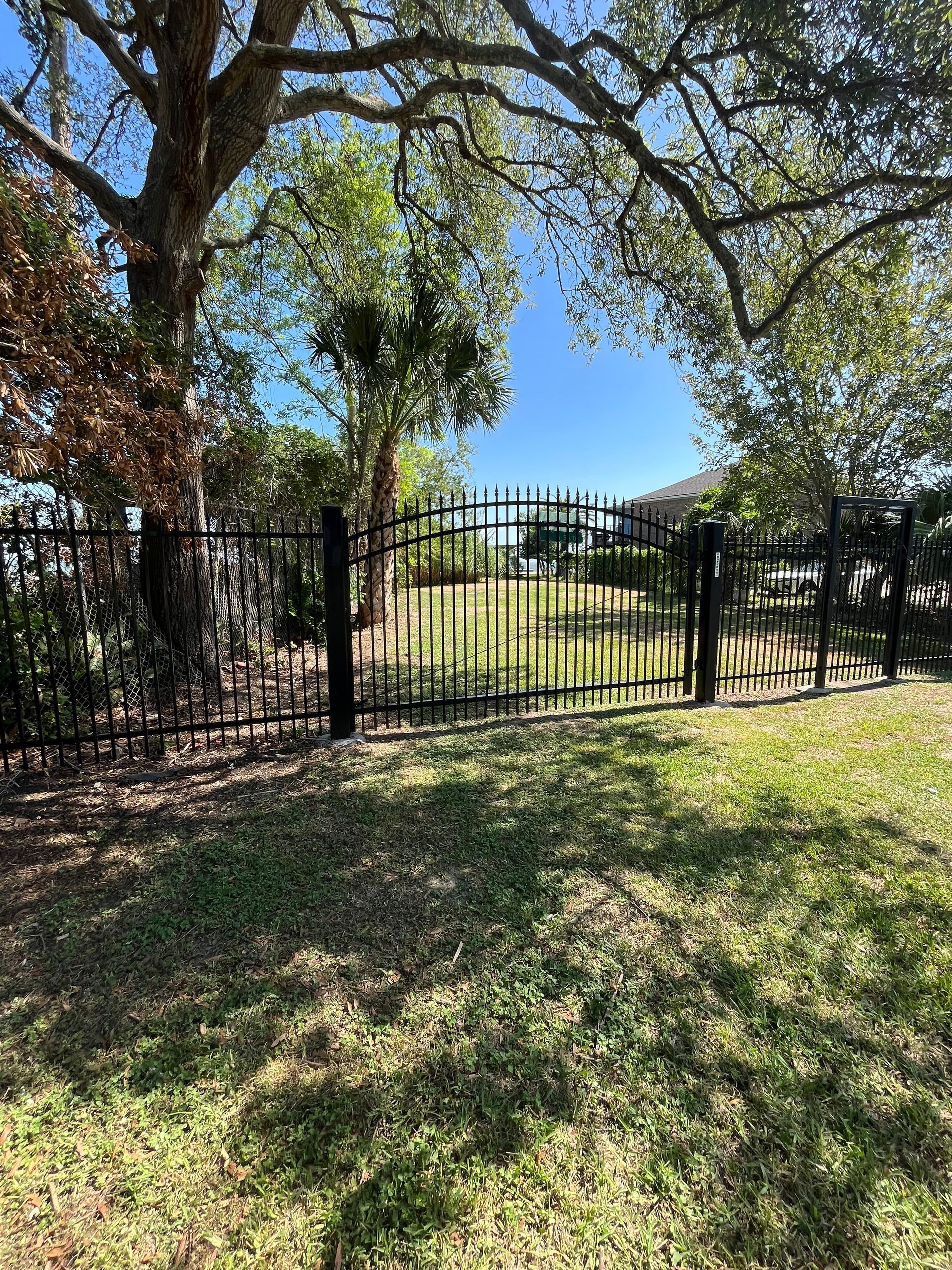 Stack of vertical slat replacement fence panels in a residential backyard, prepared for installation.