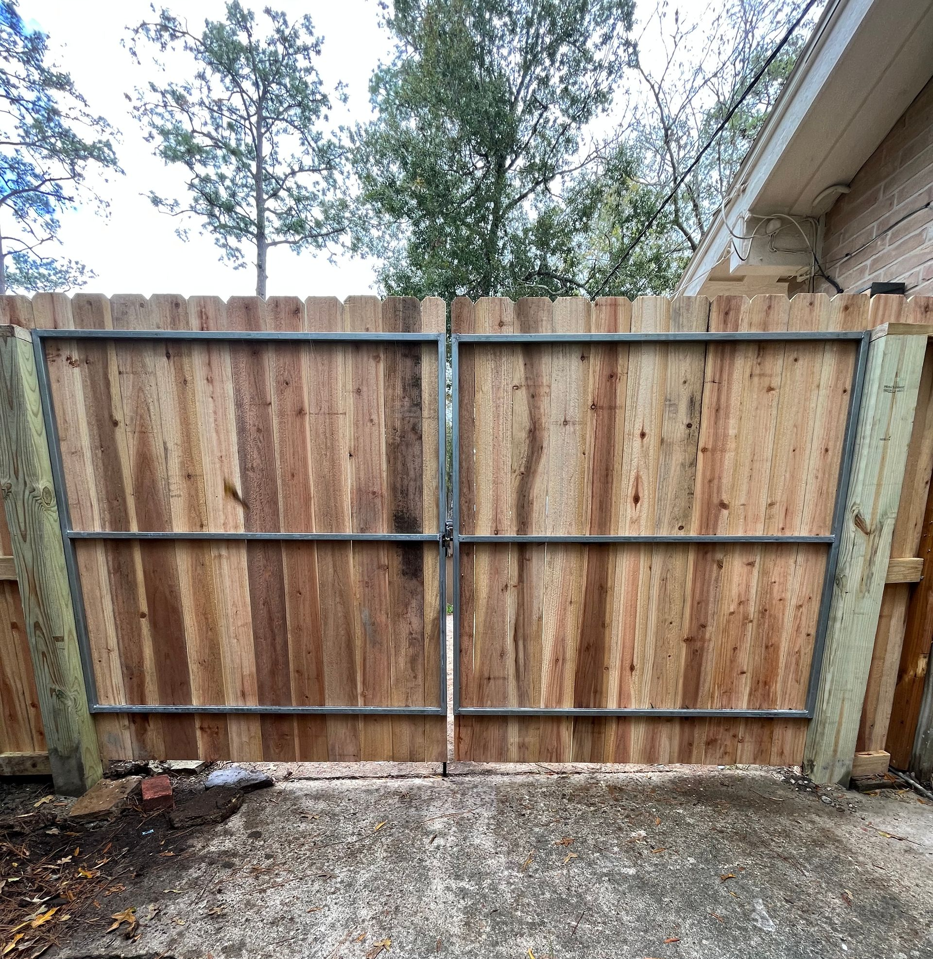Aged wooden fence near new lumber boards.
