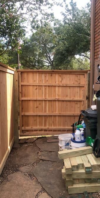 Aged wooden fence near new lumber boards.