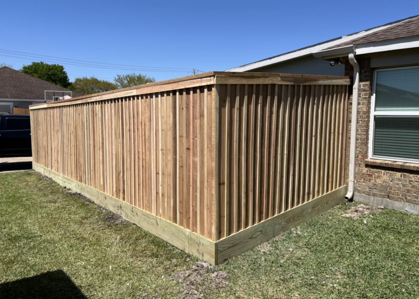 Aged wooden fence near new lumber boards.