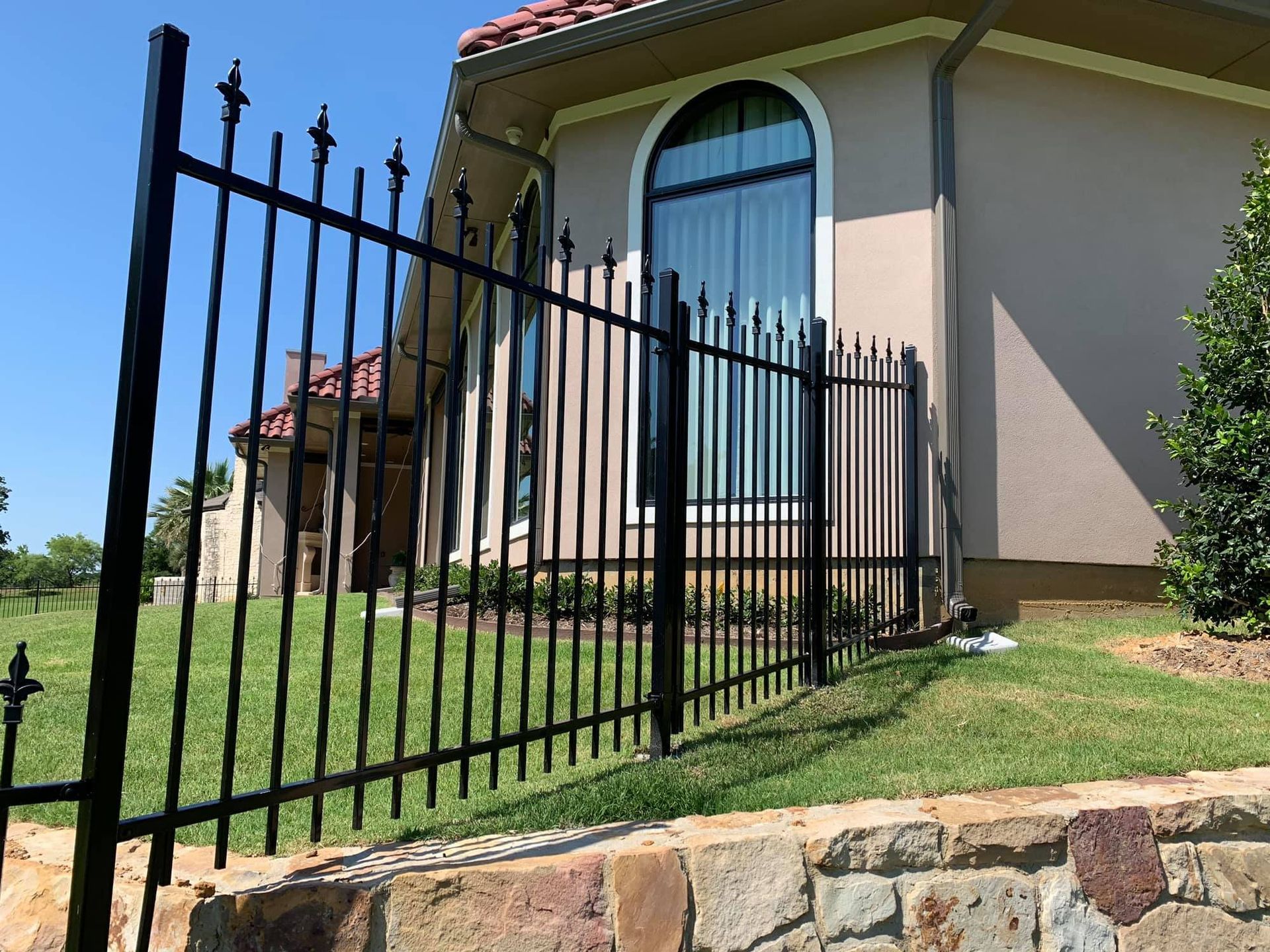Stack of vertical slat replacement fence panels in a residential backyard, prepared for installation.