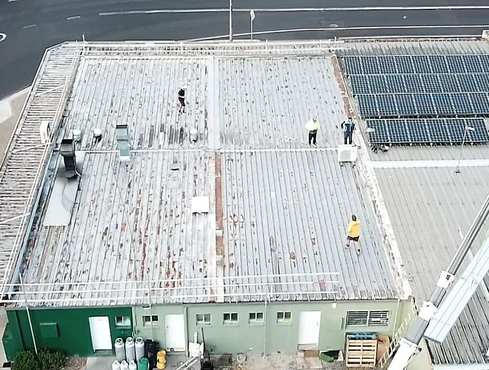 An Aerial View of a Building With Solar Panels on the Roof — Monty's Metal Roofing In Ocean Shores, NSW