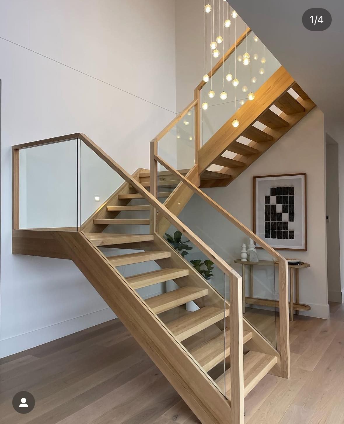 Modern wooden staircase with glass railings in a bright interior room