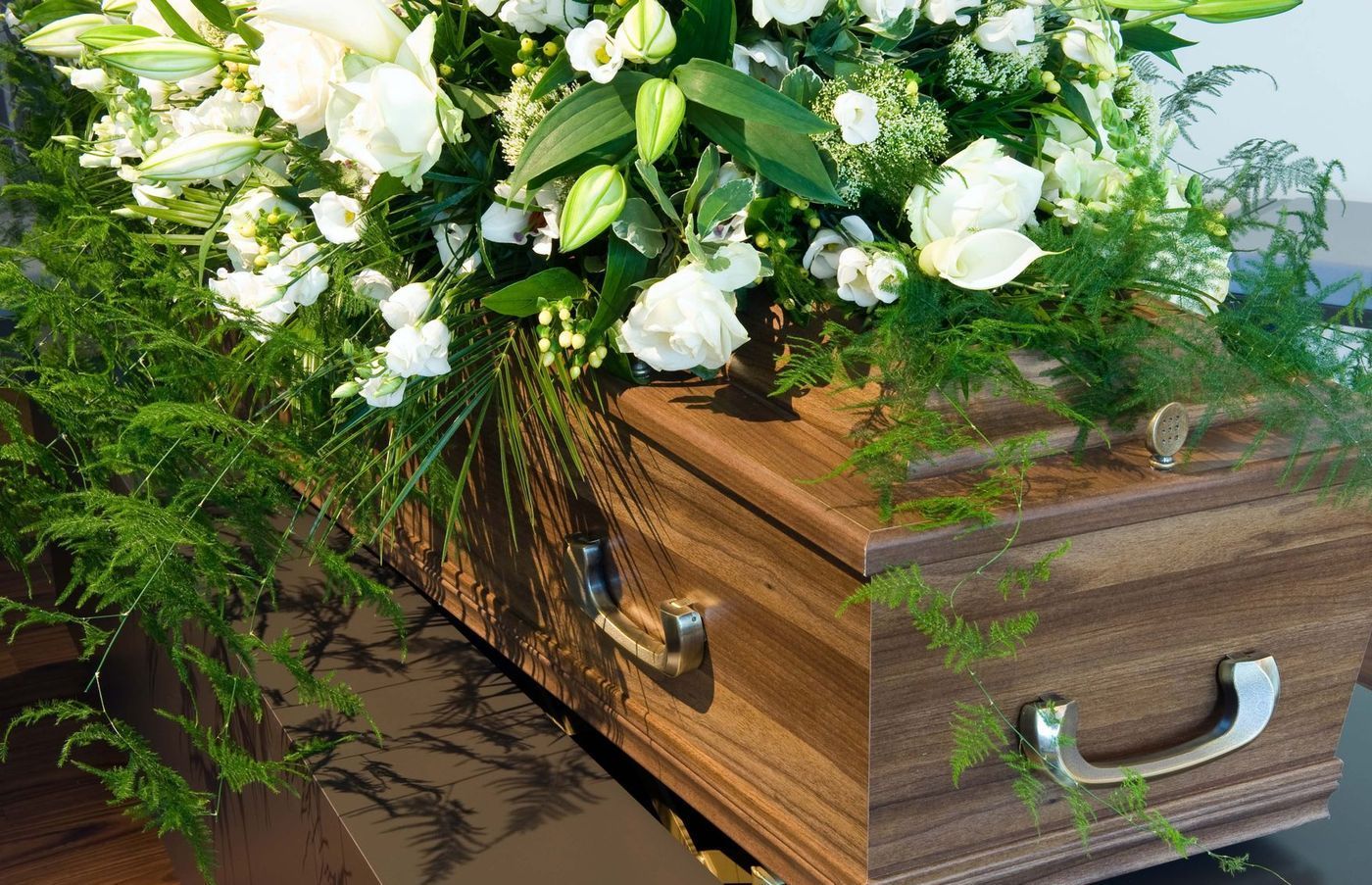 Cofanetto in legno con fiori bianchi e fogliame verde.