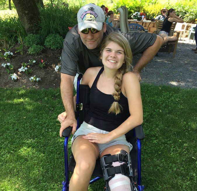 Alison Hinck in wheelchair with knee brace following knee surgery