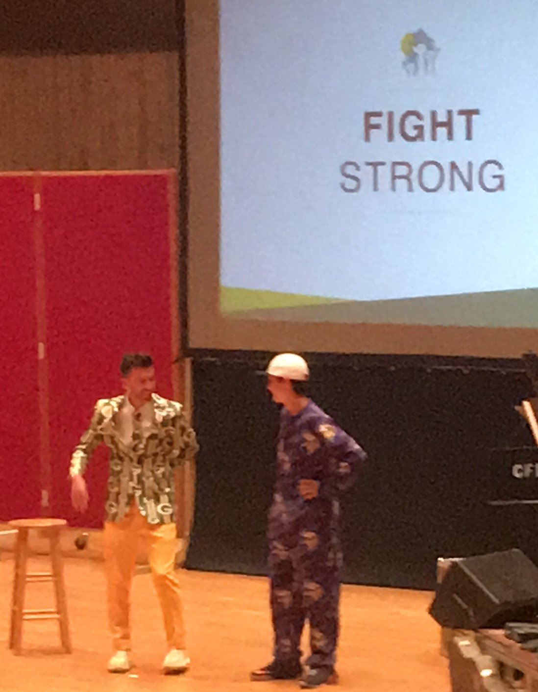High school leader performing a skit on school stage wearing funny clothing and pajamas.