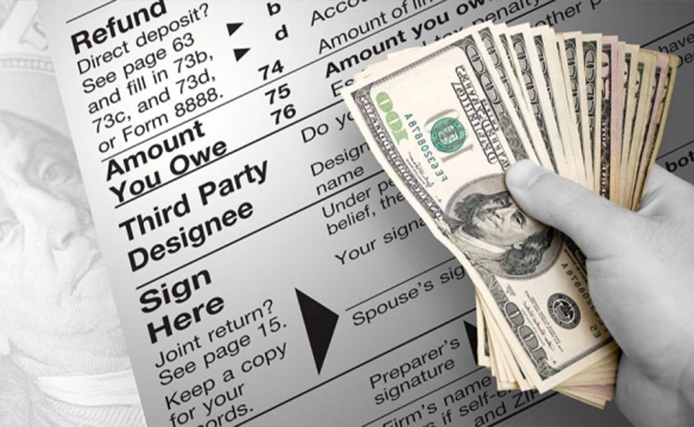 A person is holding a stack of money in front of a refund form