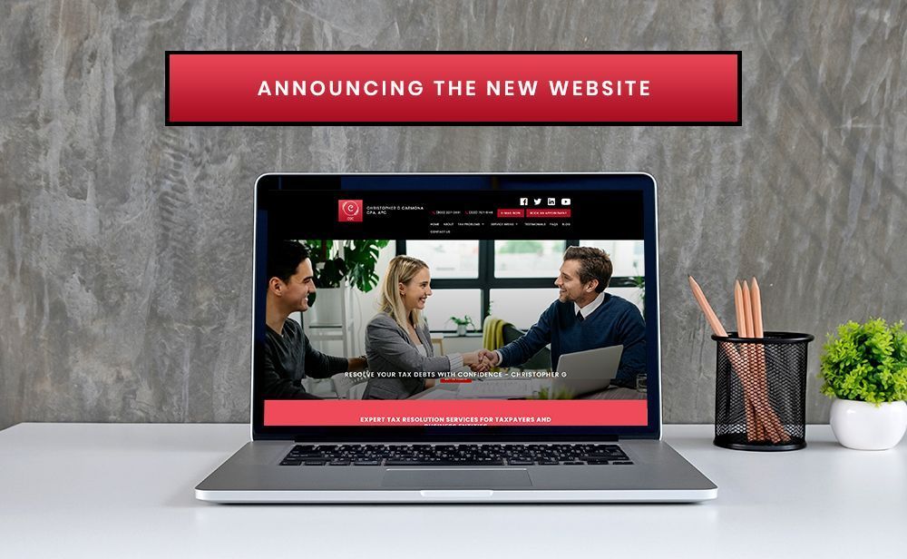 A laptop is open to a page that says announcing the new website