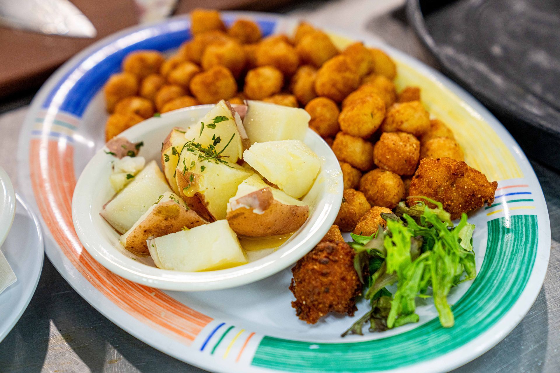 A plate of food with potatoes and fried food on a table.