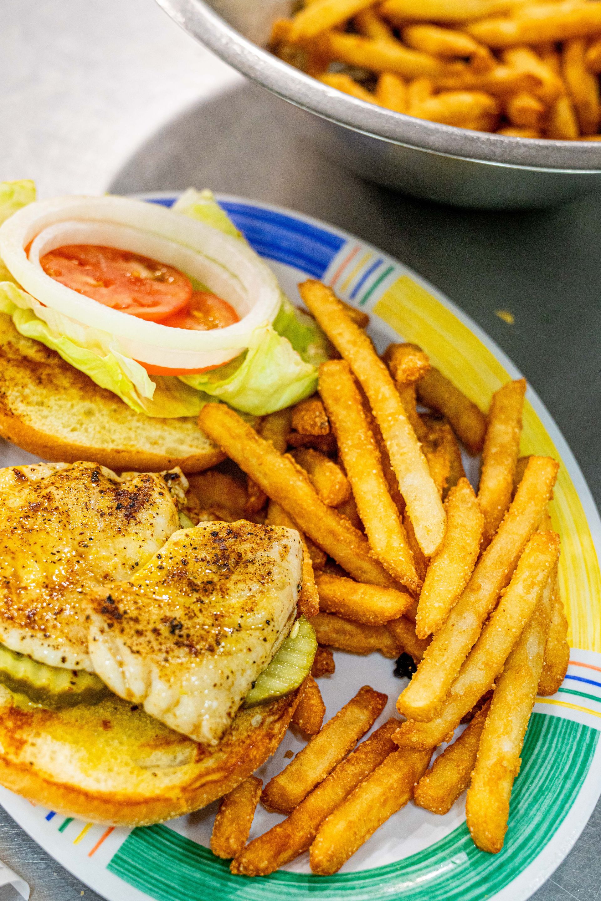 A plate of food with a sandwich and french fries on a table.