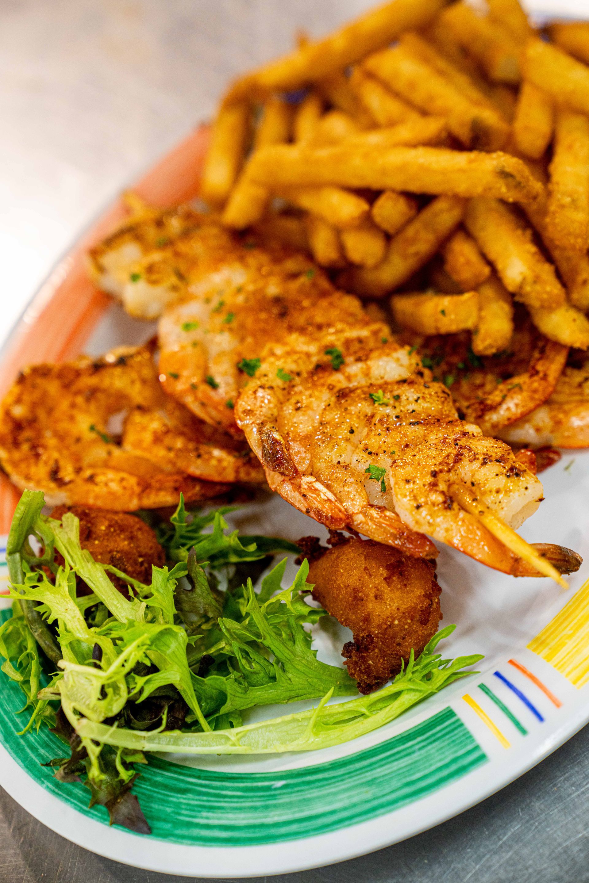 A plate of food with shrimp and french fries on a table.
