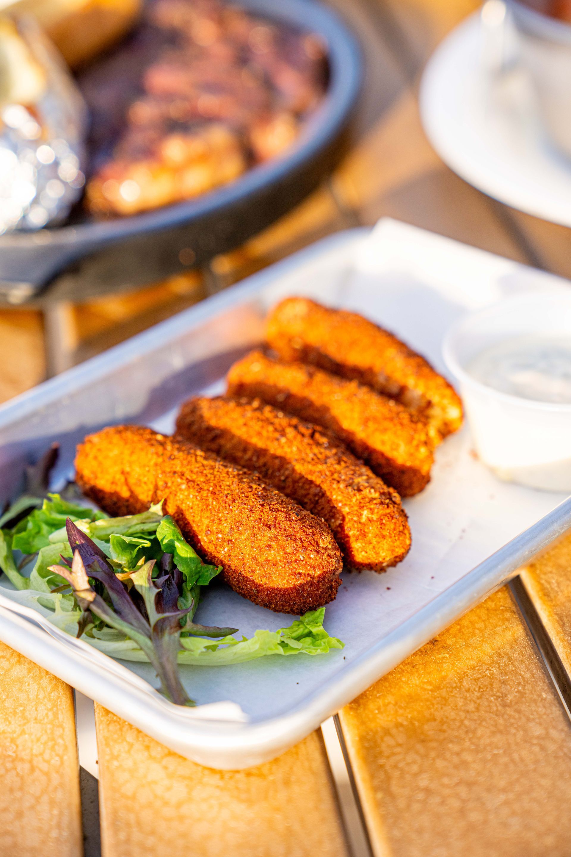 A close up of a plate of food on a wooden table.