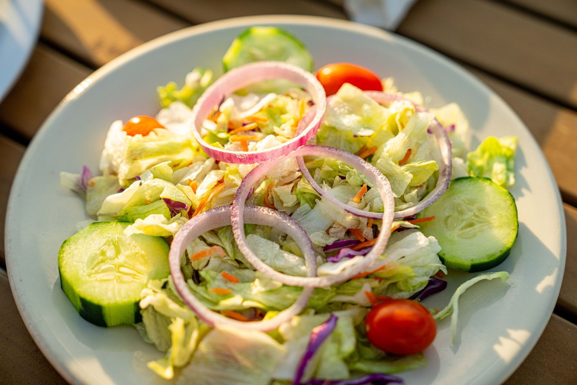A close up of a salad on a plate on a table.
