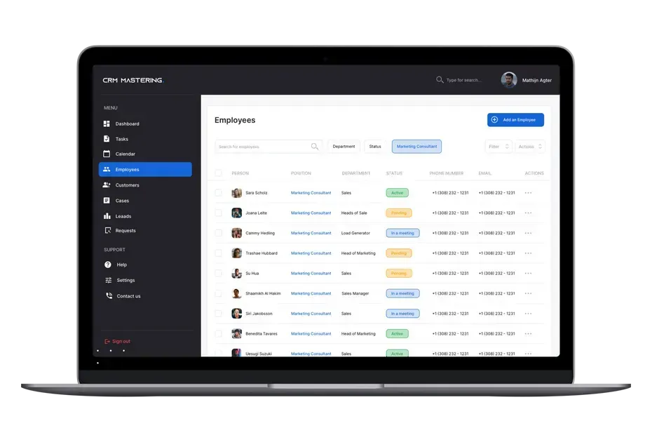 A laptop computer is open to a dashboard with a list of employees.