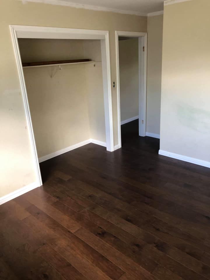 An empty room with hardwood floors and a closet.