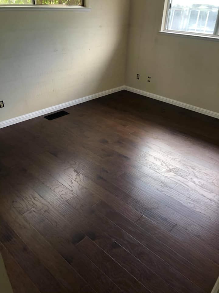 An empty room with hardwood floors and a window.