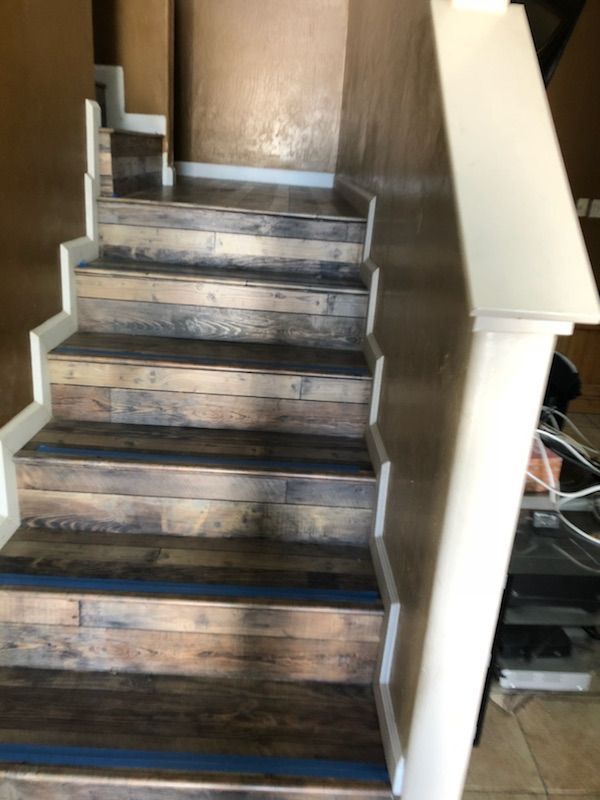 A set of wooden stairs with a white railing