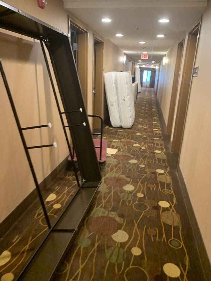 A hallway in a hotel with a mattress on the floor