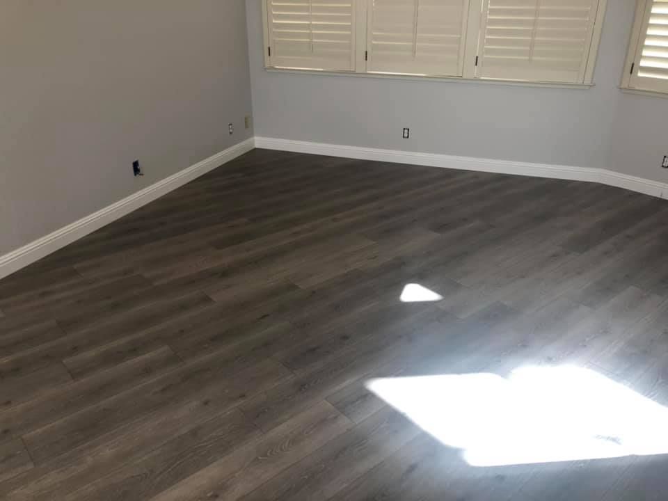 An empty room with a wooden floor and shutters on the windows.