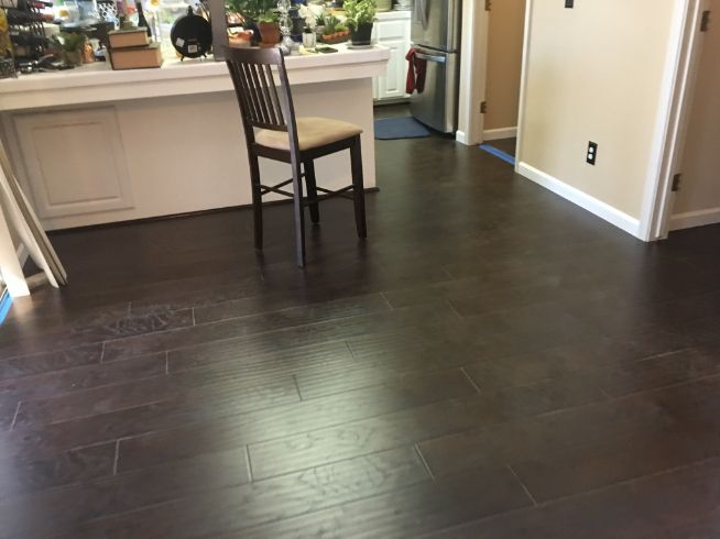 A chair is sitting on a wooden floor in a kitchen.