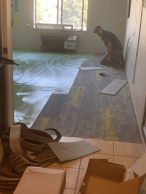 A man is kneeling on the floor in a room.