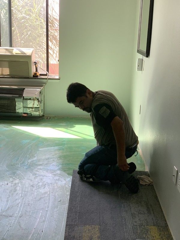 A man is kneeling on the floor in a room