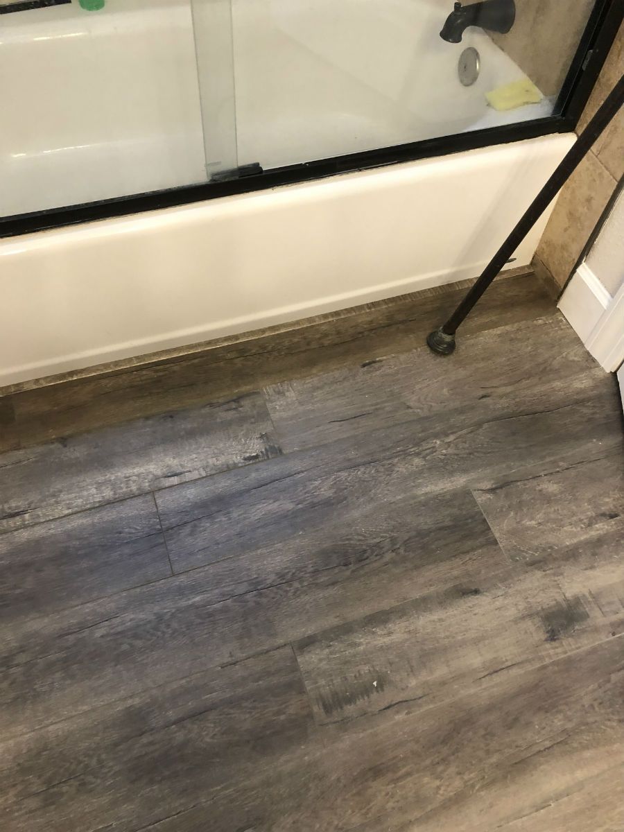 A bathroom with a bathtub and a cane on the floor.