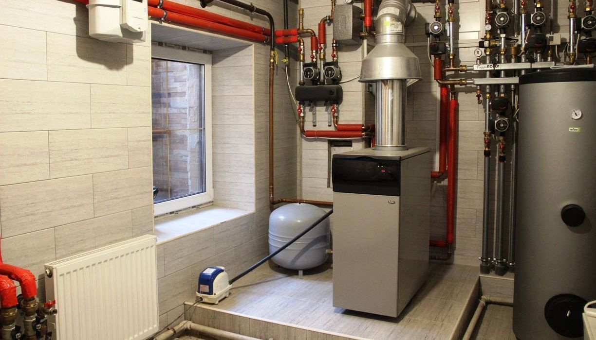 A room with a boiler and a window in it.