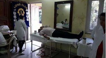 A man is laying on a table in a room with a mirror.