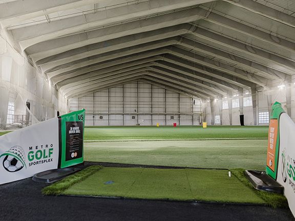Interior golf driving range with plenty of open spans thanks to pre-engineering.