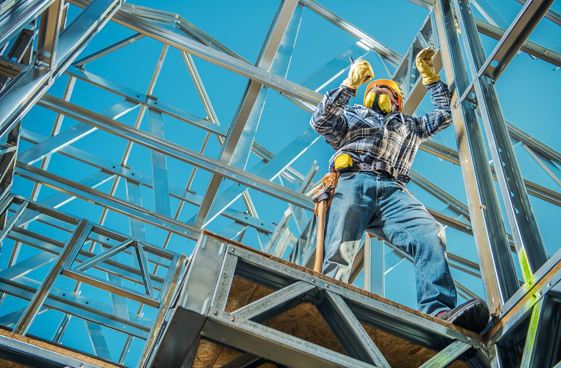 Skilled tradesman installs metal framing on new industrial building.