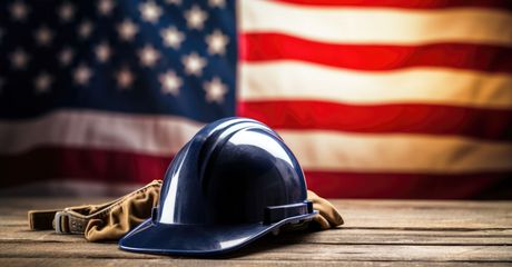 Construction helmet in front of an American flag.