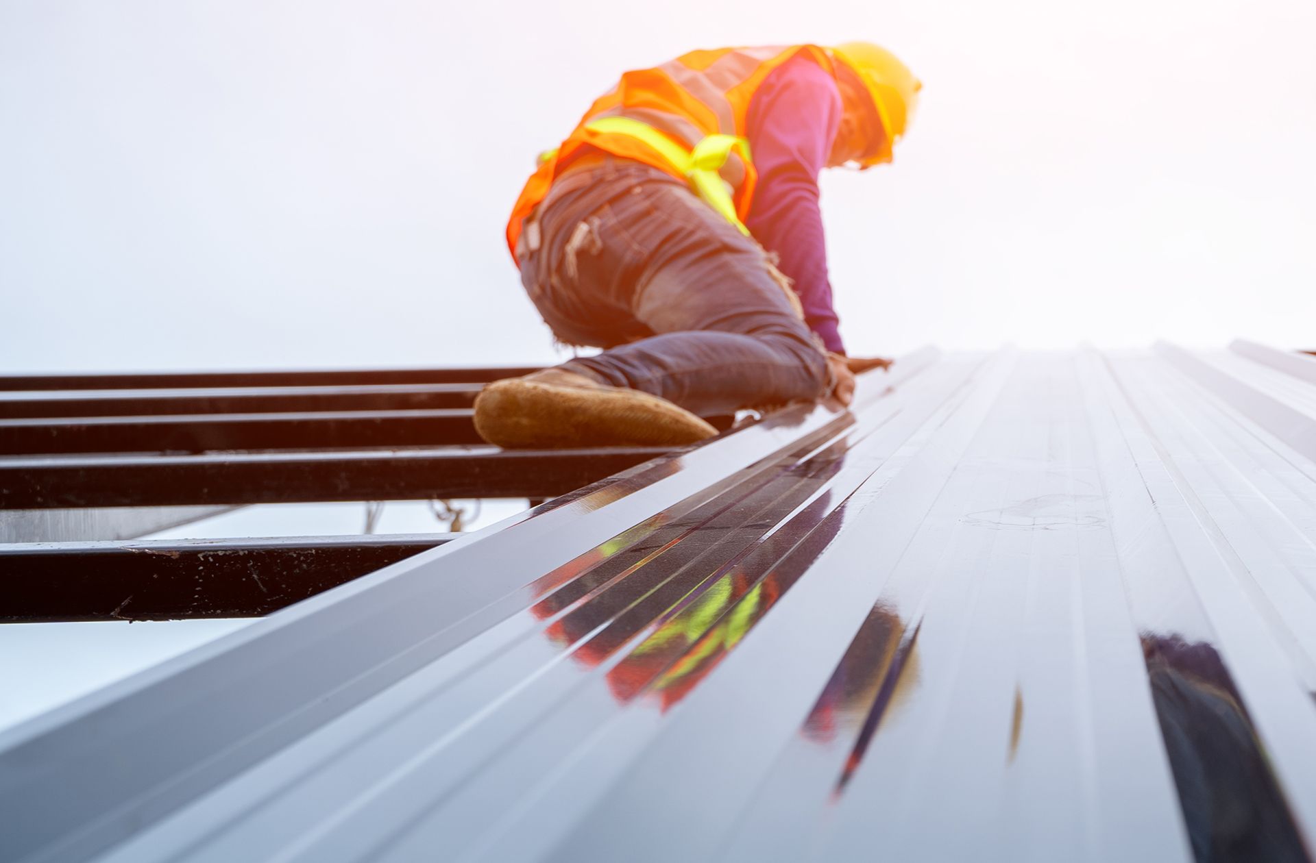 Skilled ironworker adds an exterior panel to a pre-engineered metal building.