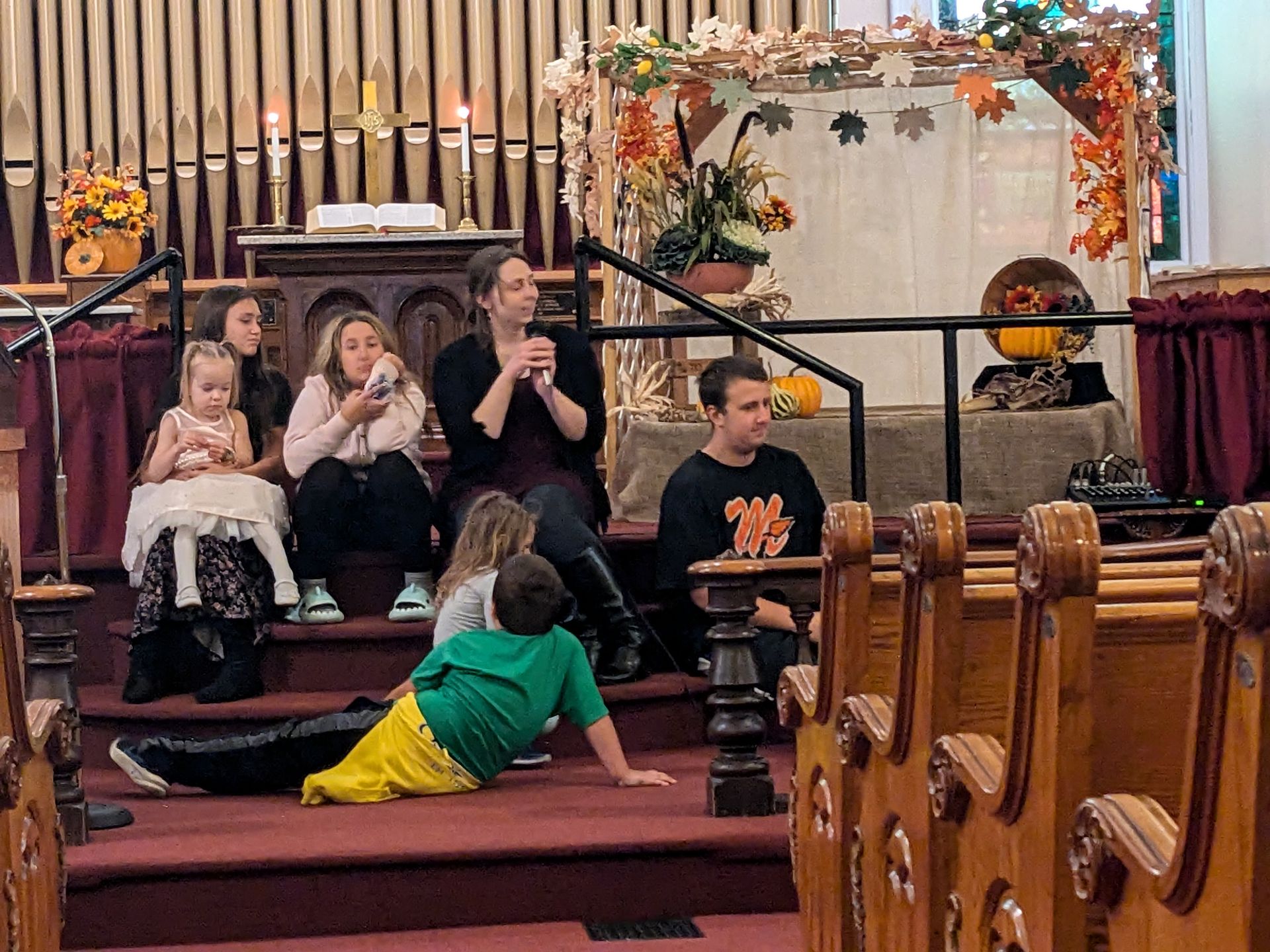 A group of people are sitting on the steps of a church.