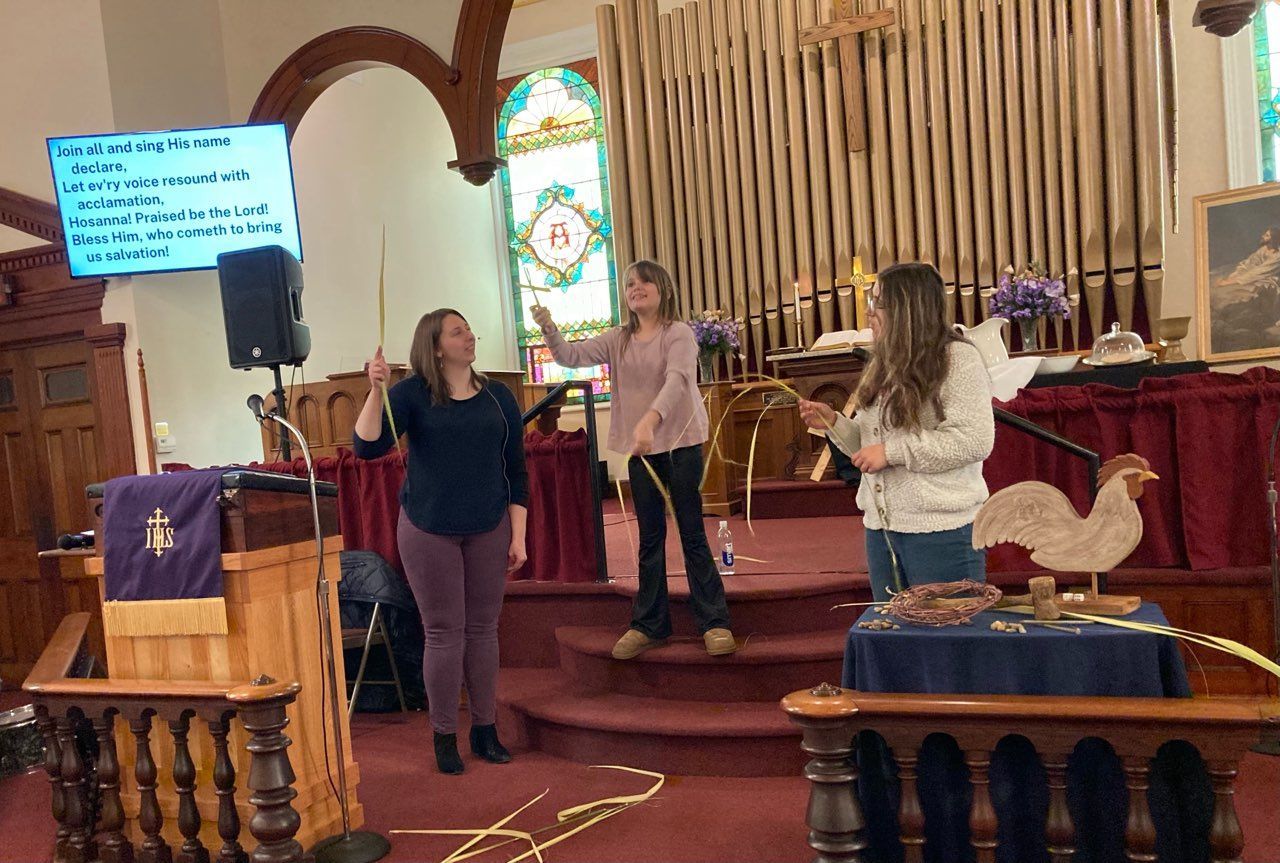 Three women are standing in front of a podium in a church.