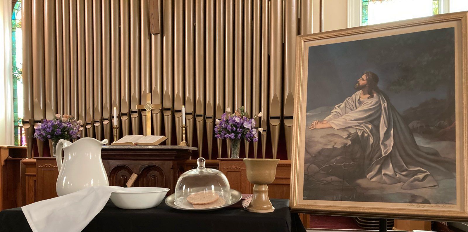 A painting of jesus is sitting on a table in a church.